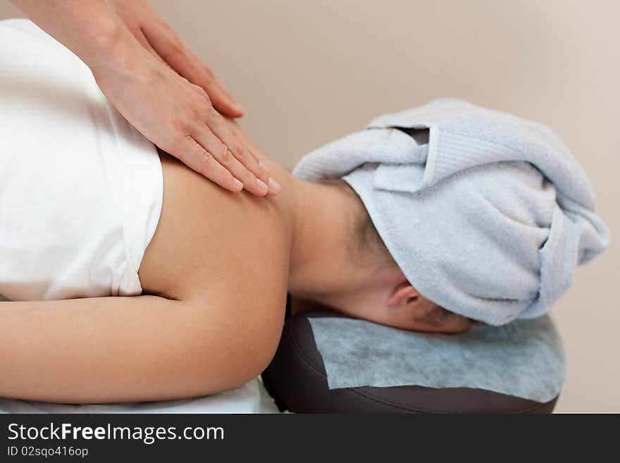 Young woman in a spa salon lays on a table and receives a facial massage