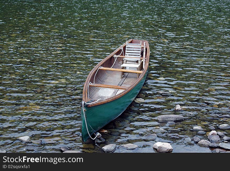 Small canoe with a seat for fishing on the river. Small canoe with a seat for fishing on the river.