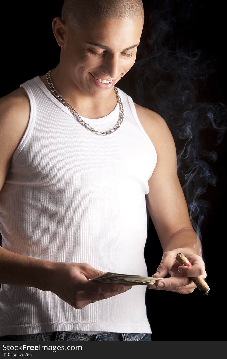 A good looking, muscular built, man on a black background smoking cigar. A good looking, muscular built, man on a black background smoking cigar.