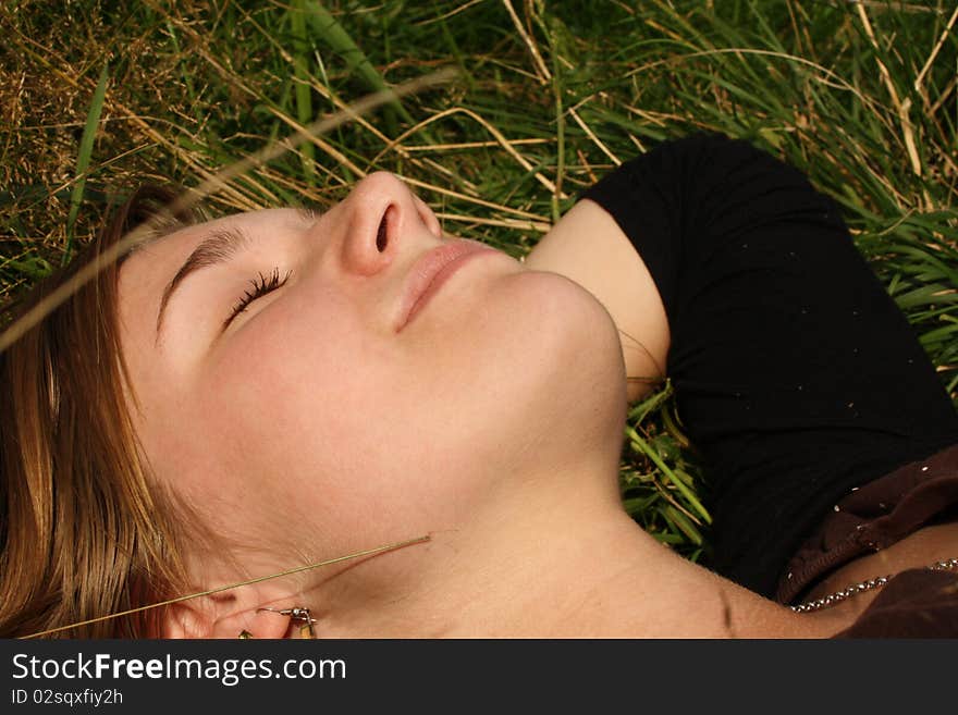 Young woman dreaming in grass.