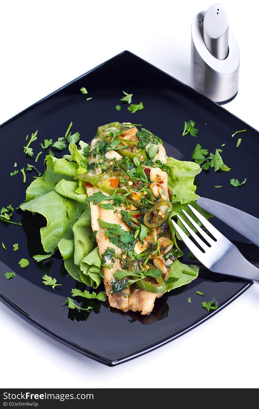 Oven cooked fish on a black plate