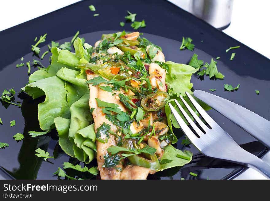 Oven cooked fish on a black plate