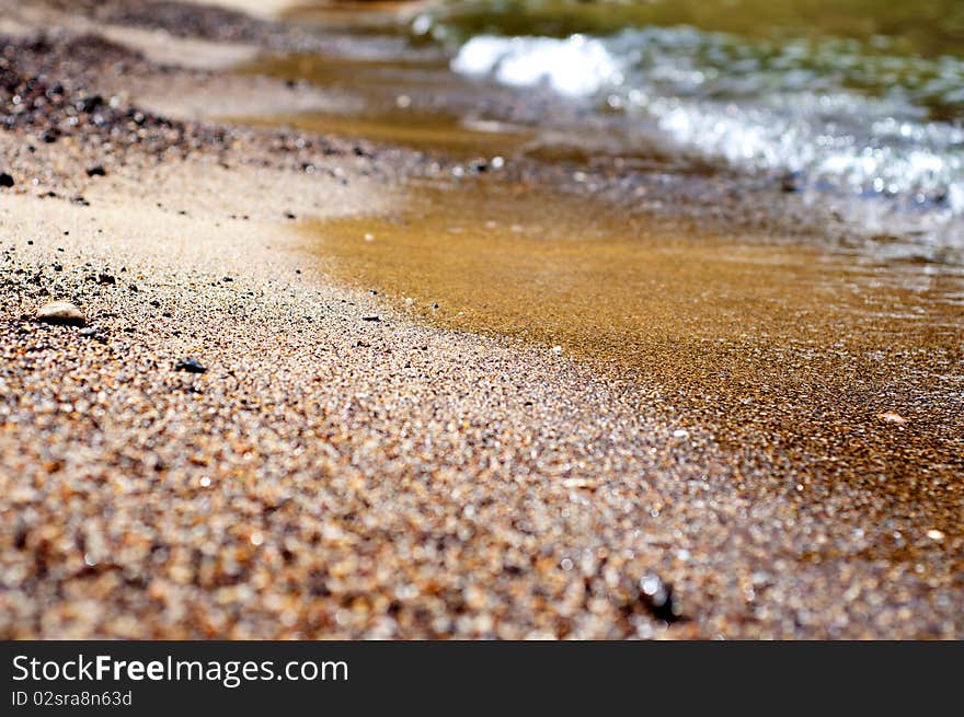 Seashore with waves and foam and blue sky