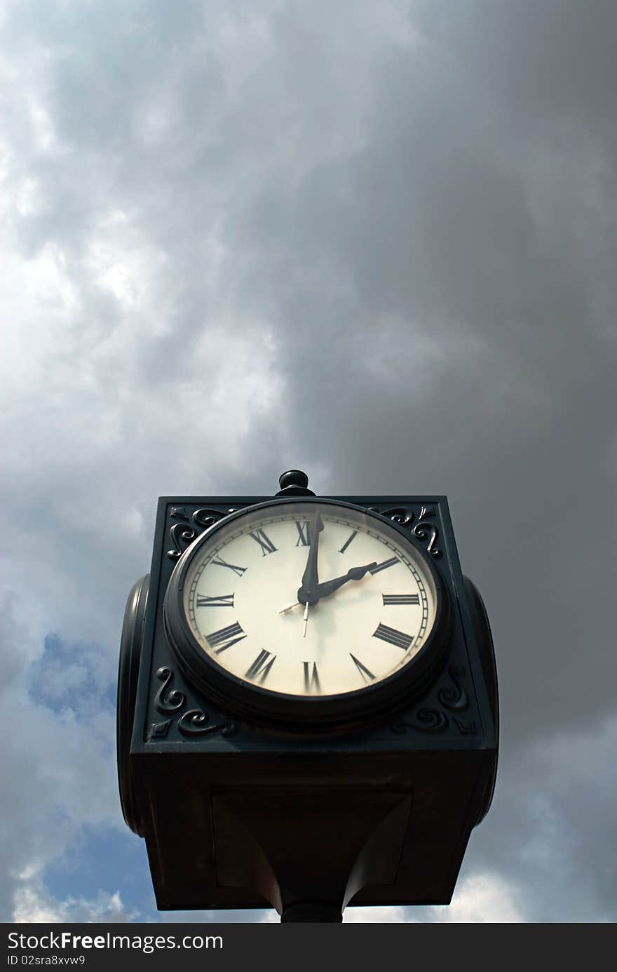 Retro clock against moody sky.