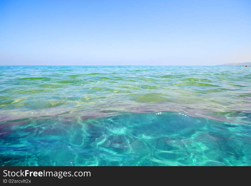 Seashore with waves and foam and blue sky