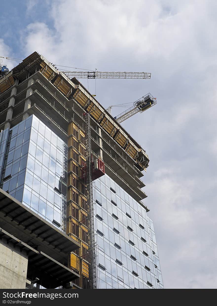 Condominium tower under construction with cranes. Condominium tower under construction with cranes