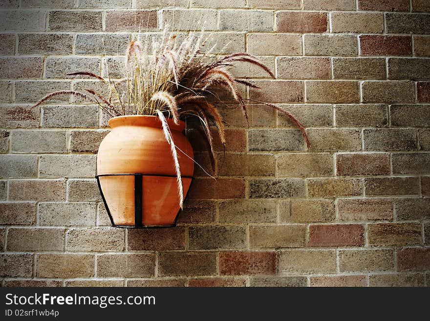 Old grass pot on brick wall