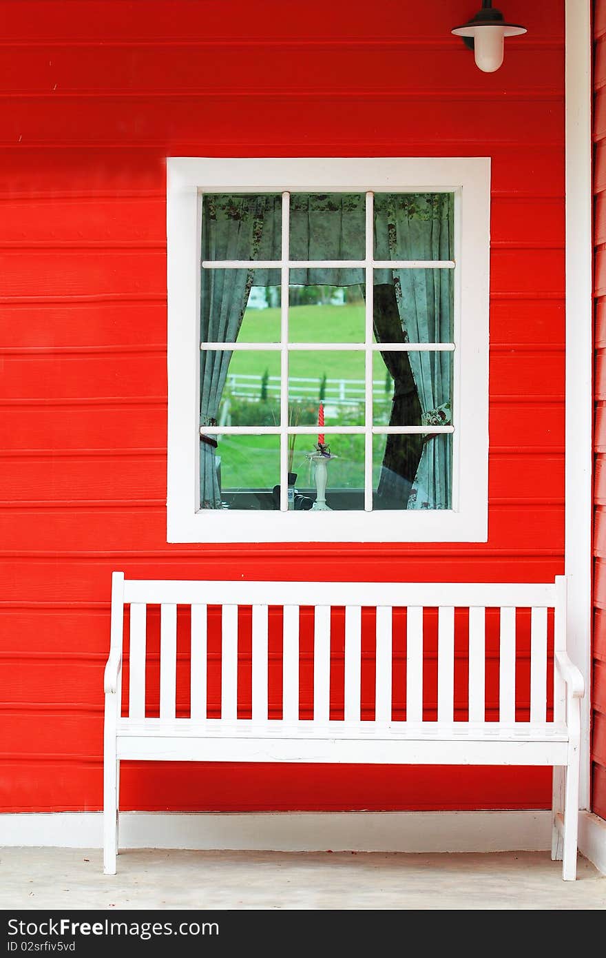 White chair against white window and red wall