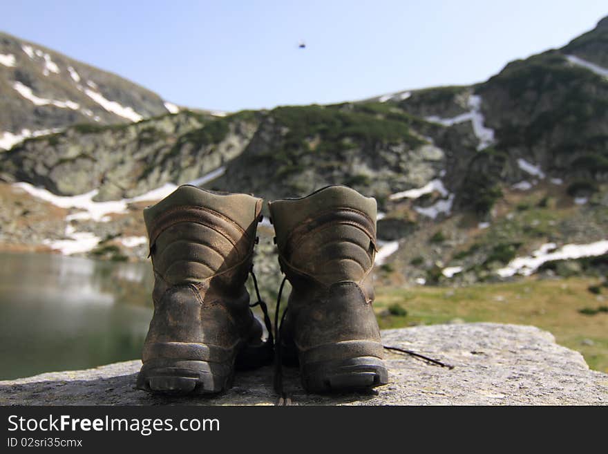 Hiker's boots  over a lake in Parang mountains, Romania. Hiker's boots  over a lake in Parang mountains, Romania