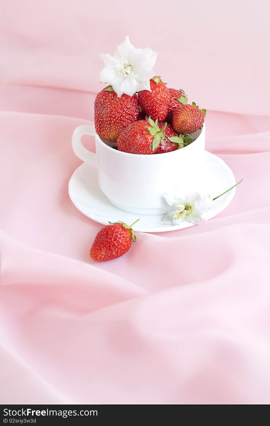 Full cup ripe strawberry on a pink background