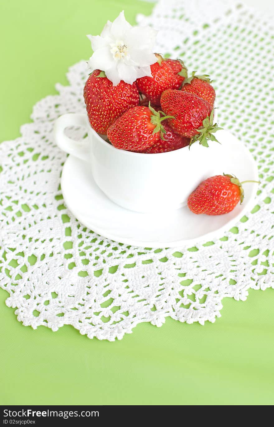 Cupful of ripe strawberries lace in green background