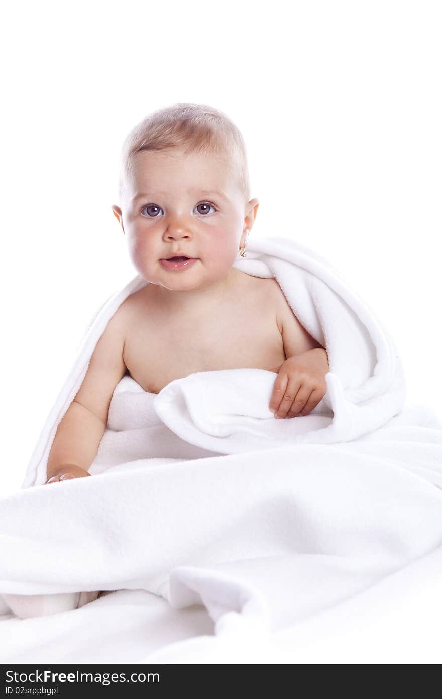 Beautiful baby under a white towel on white background