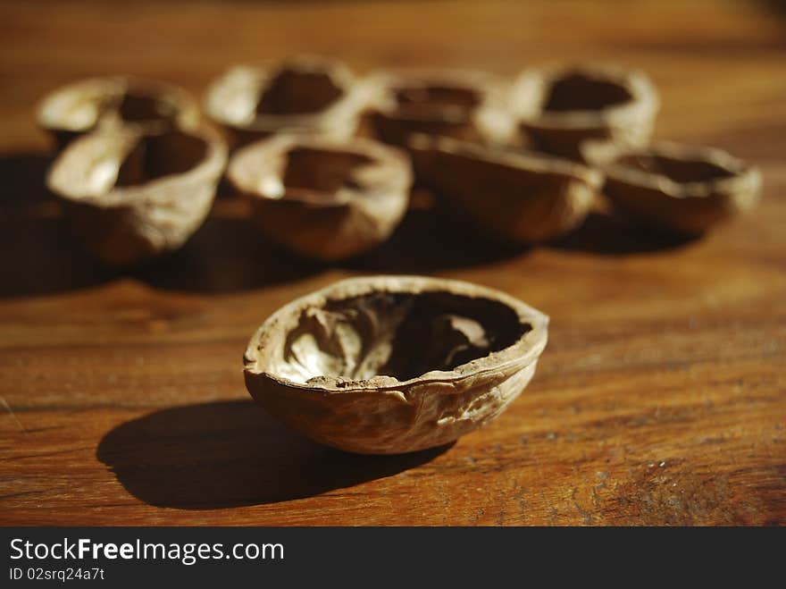 A series of  walnuts shells arranged on a table. A series of  walnuts shells arranged on a table