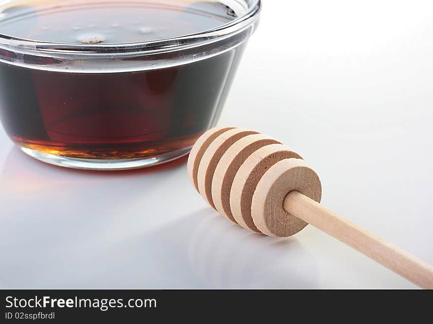 Honey in glasswares with wooden honey dipper.