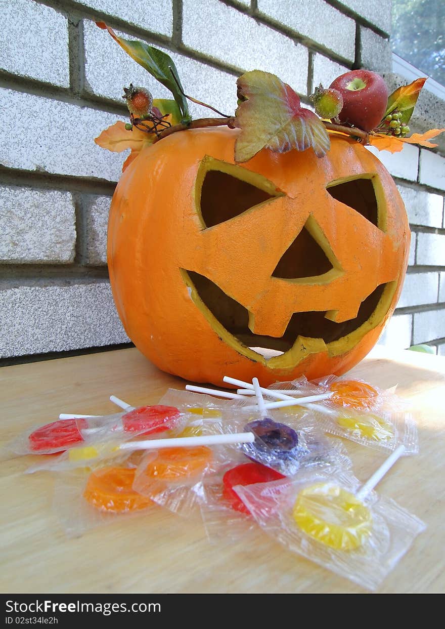 Plastic pumpkin with leafs ornament and candies. Plastic pumpkin with leafs ornament and candies