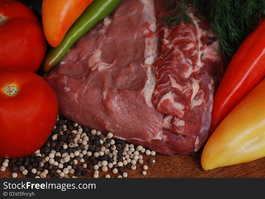 Raw beef with multicolored pepper, tomato and paprika. Selective focus. Raw beef with multicolored pepper, tomato and paprika. Selective focus