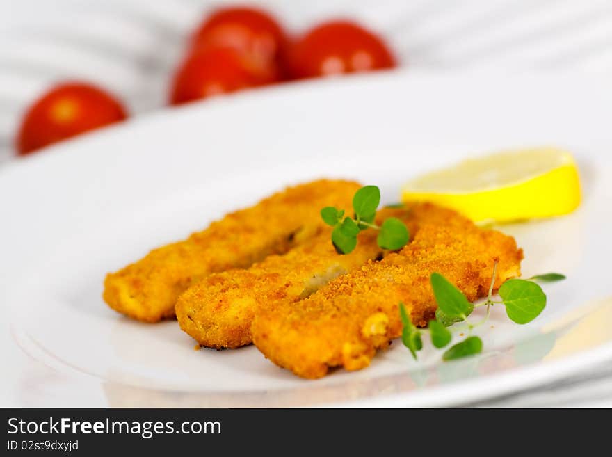 Close up,three fish fingers and slice of lemon.