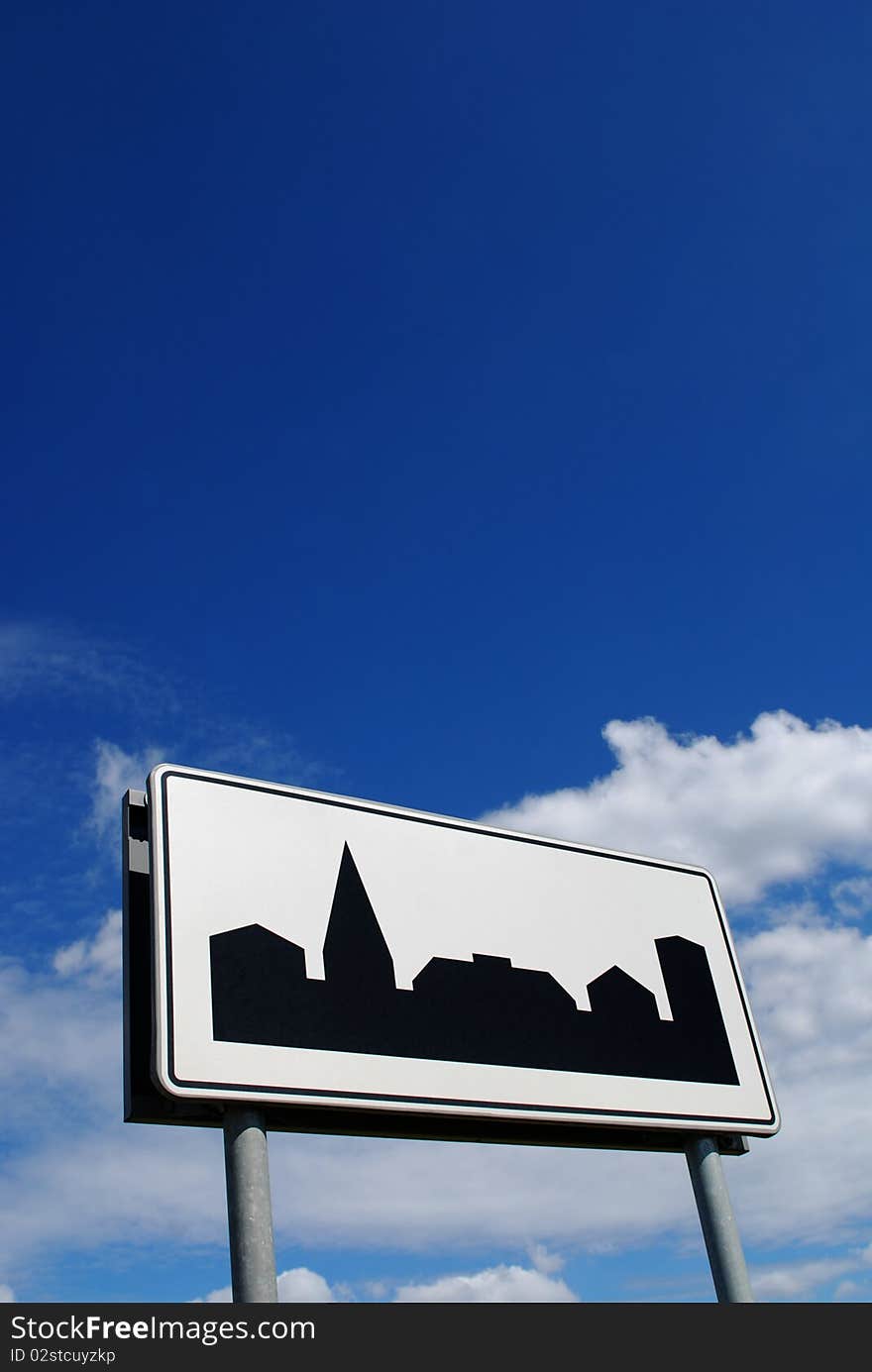 City sign against the blue cloudy sky