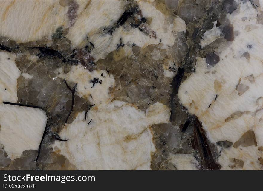 Surface of the stone. Granite. Pale yellow and reddish-brown shades. Mottled pattern.