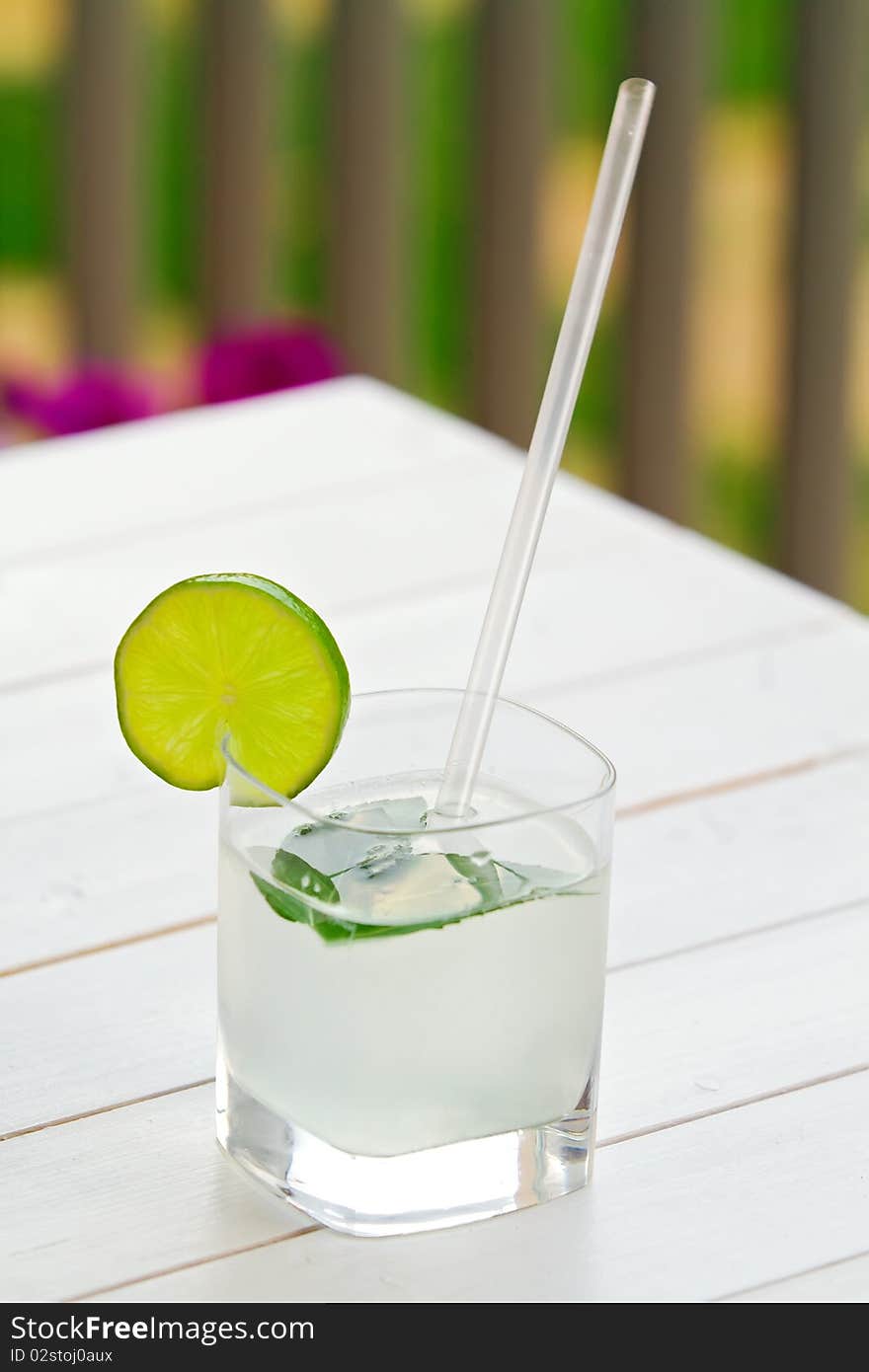 Glass of lime juice on white wooden table