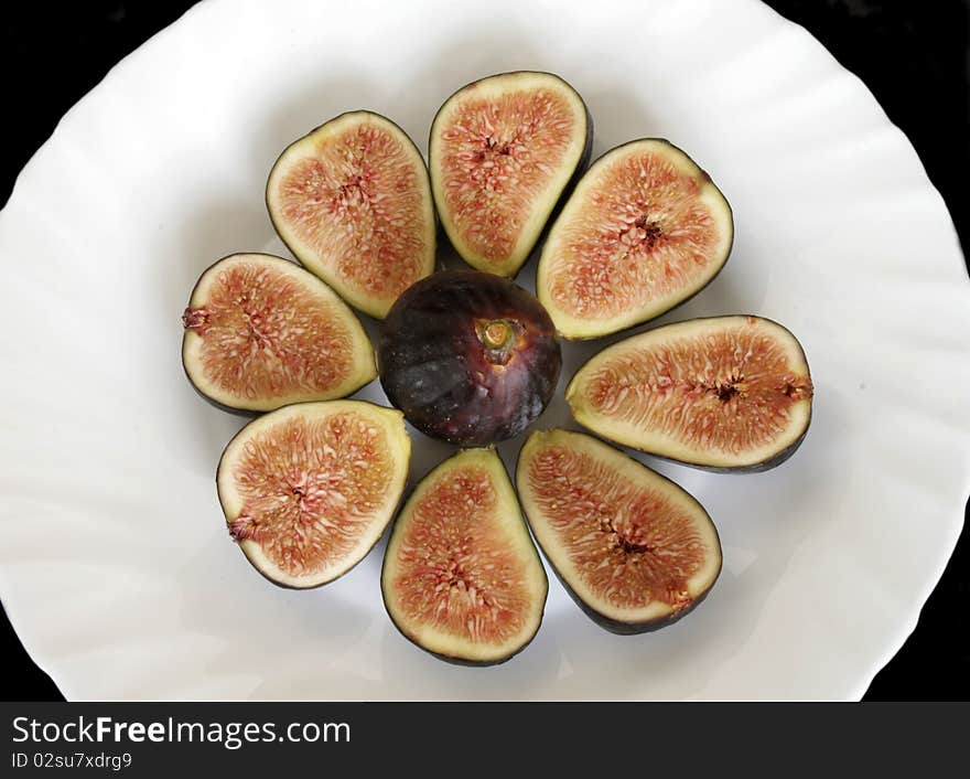 Ripe sliced figs on the plate in isolated over black