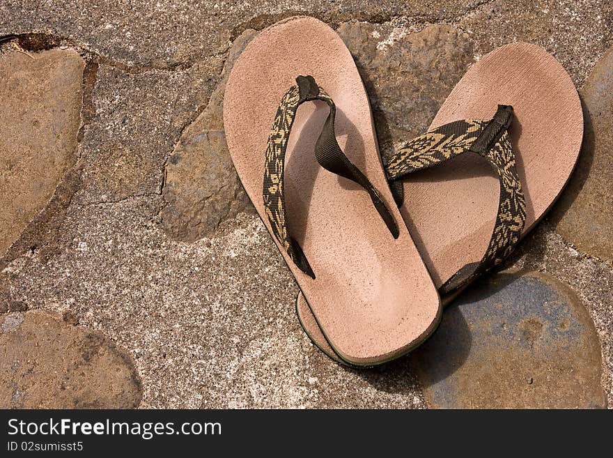 Sandals on a rocky walkway.