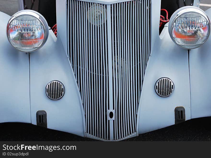 Closeup of a classic vintage car displayed outdoors.