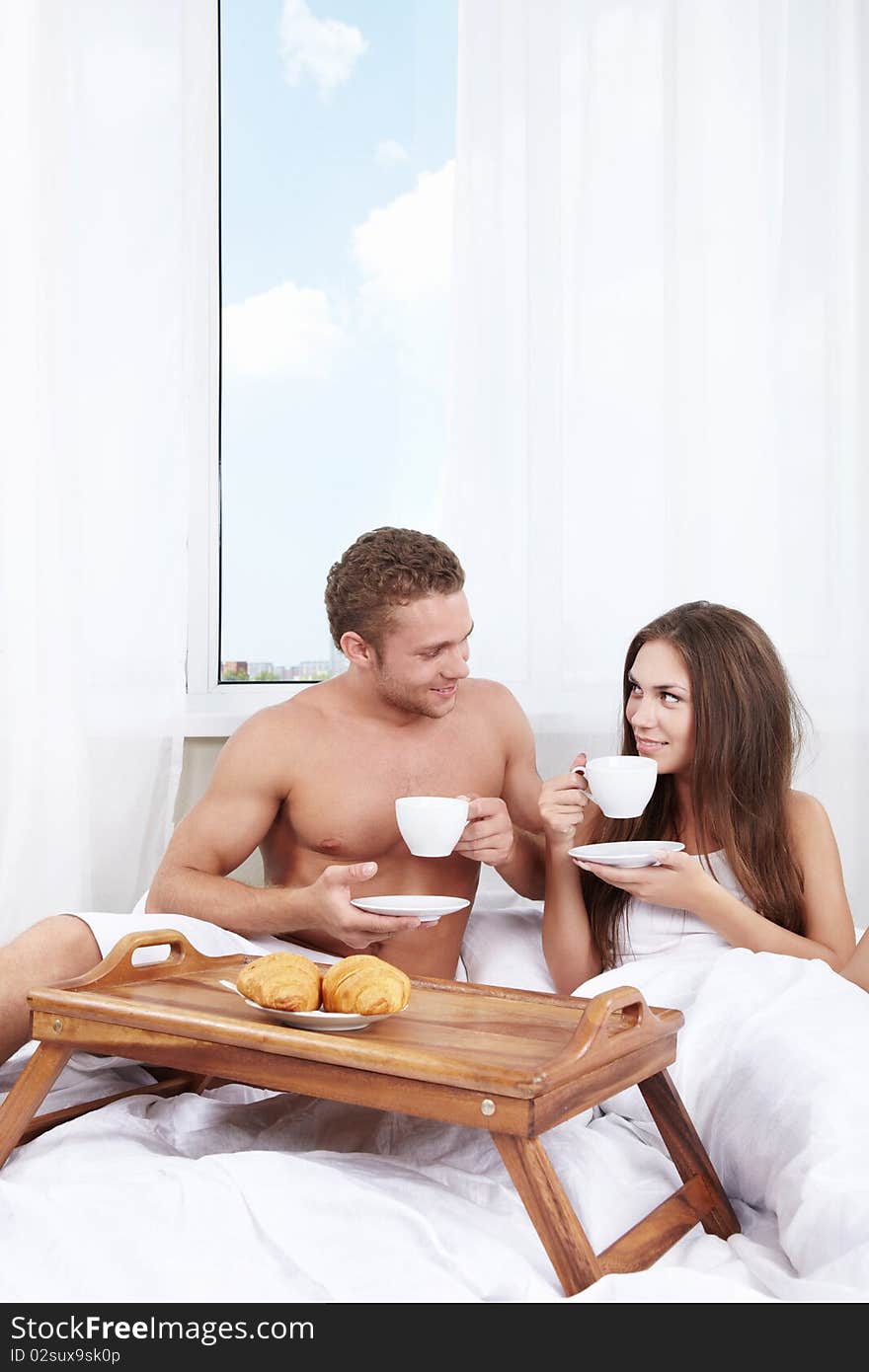 Young couple at breakfast in the bedroom. Young couple at breakfast in the bedroom