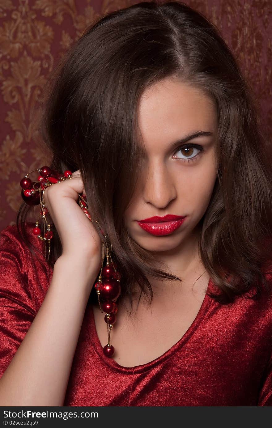 A beautiful girl with red lips is holding the beads in their hands. A beautiful girl with red lips is holding the beads in their hands.