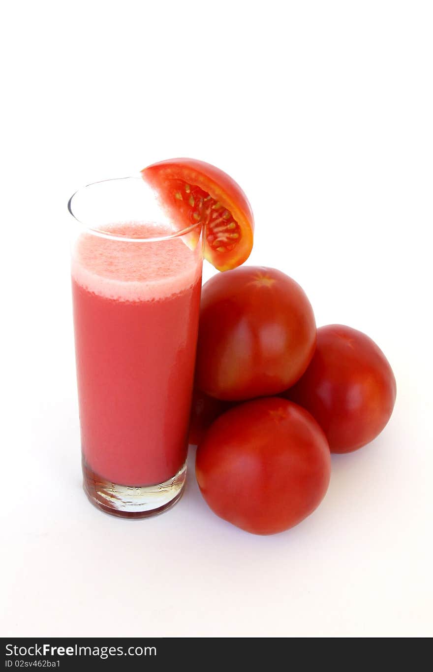 Fresh tomatoes and a glass full of tomato juice isolated on a white background. Fresh tomatoes and a glass full of tomato juice isolated on a white background