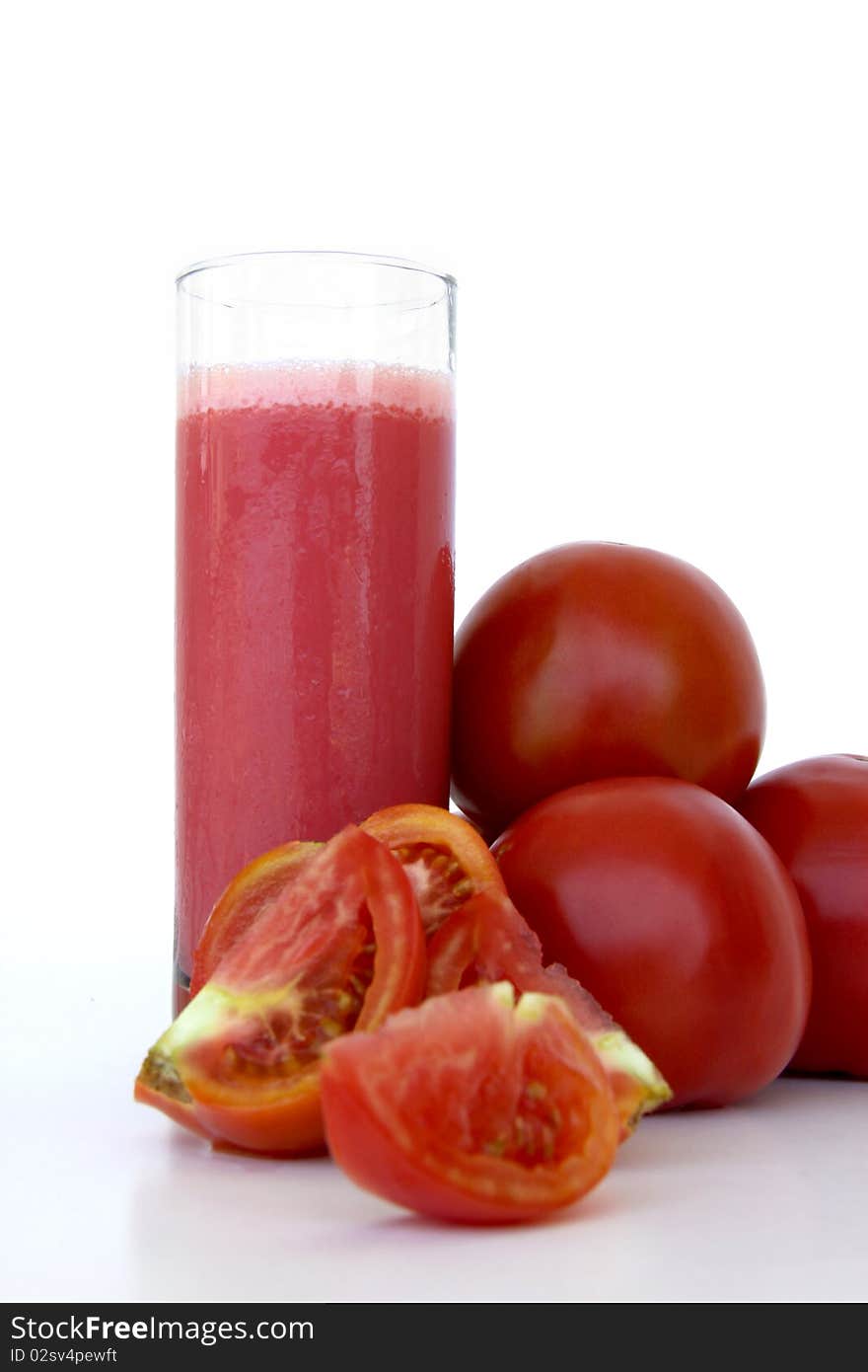 Fresh tomatoes and a glass full of tomato juice isolated on a white background. Fresh tomatoes and a glass full of tomato juice isolated on a white background