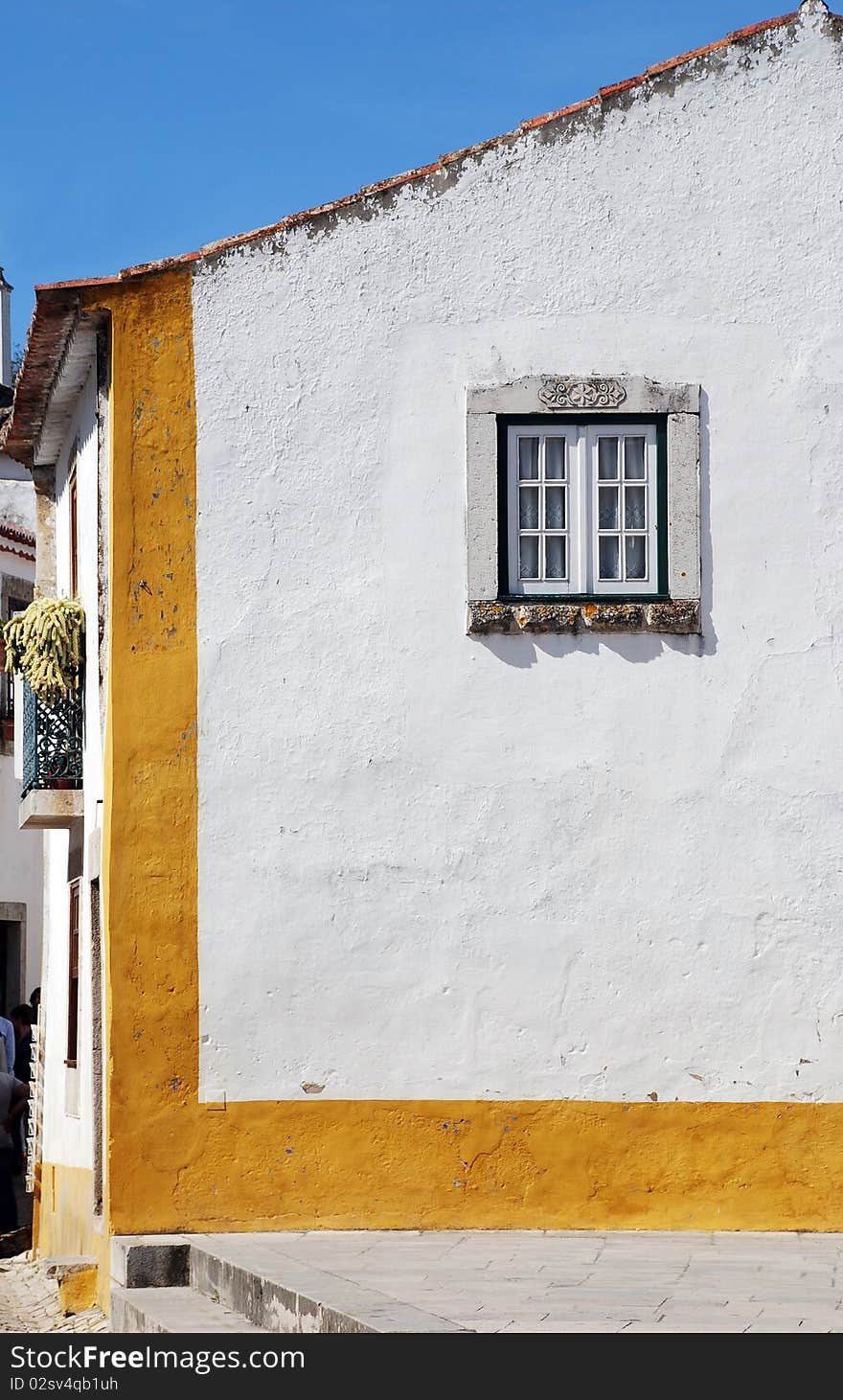 Old european house with white wall and window in sunny day(Obidos, Portugal). Old european house with white wall and window in sunny day(Obidos, Portugal)