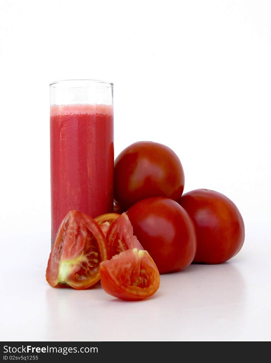 Fresh tomatoes and a glass full of tomato juice isolated on a white background. Fresh tomatoes and a glass full of tomato juice isolated on a white background