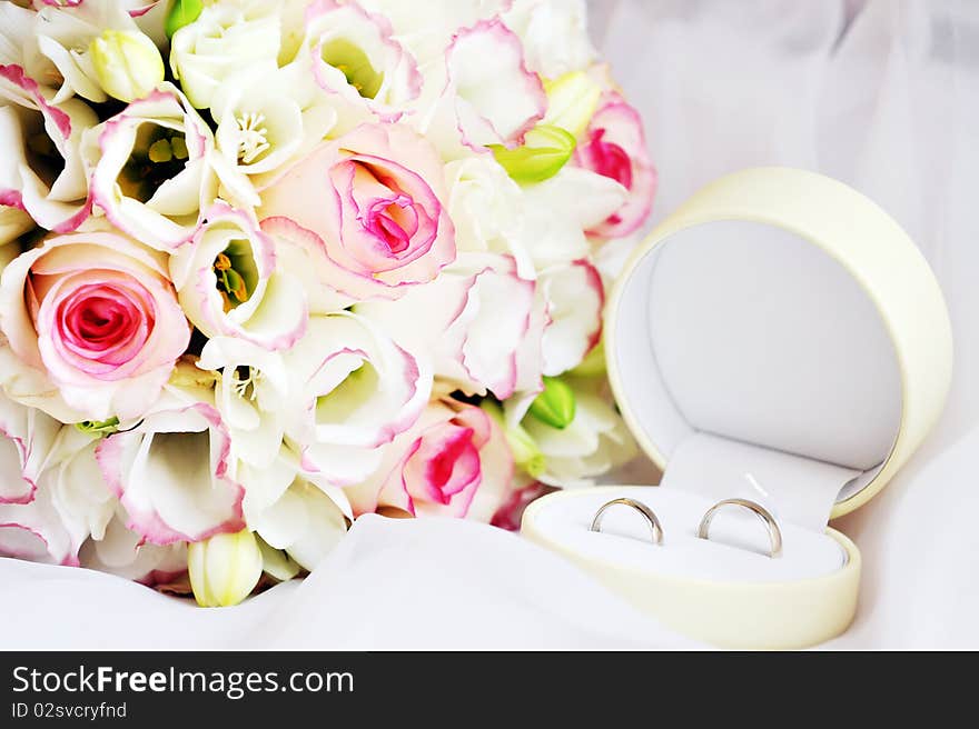 Wedding rings and bouquet of roses