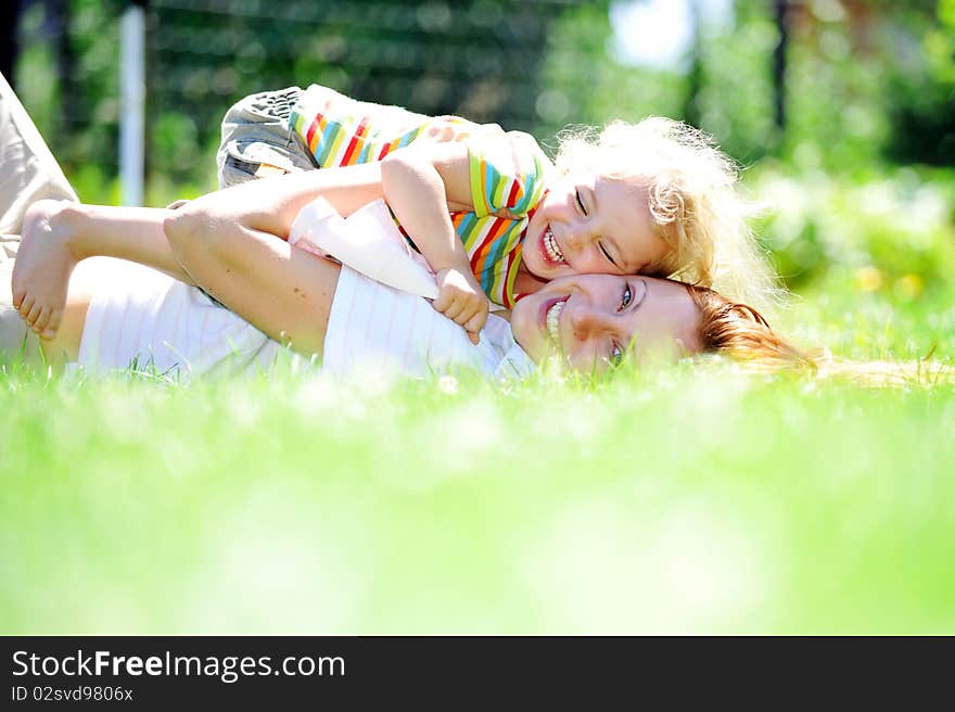 Beautiful young mother with her  daughter playing on grass . summer. Beautiful young mother with her  daughter playing on grass . summer.