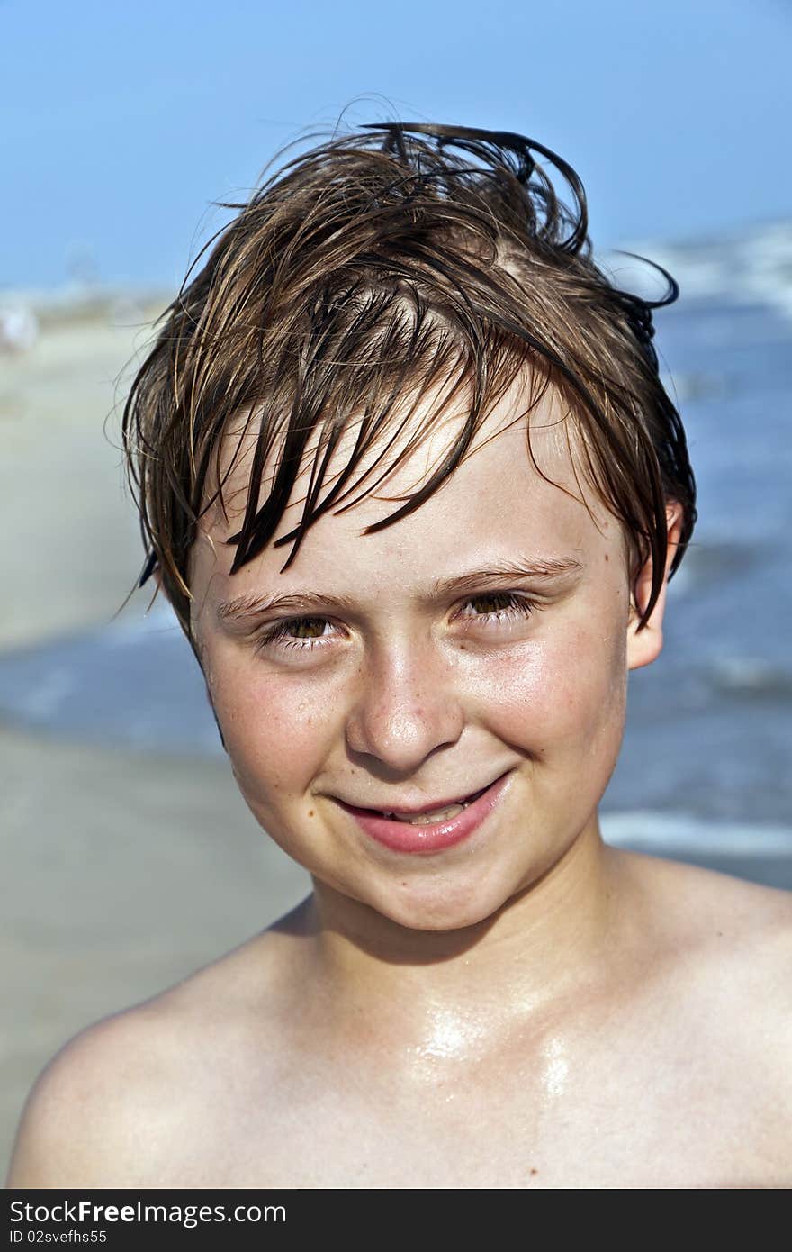 Happy boy with wet hair at the beach