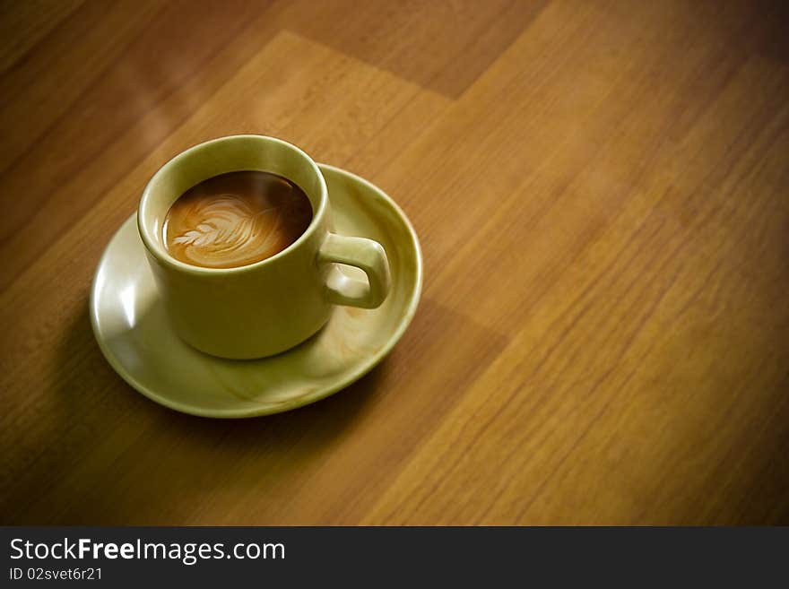 Coffee (cappuccino) with Little Art over wooden shaded background. Coffee (cappuccino) with Little Art over wooden shaded background