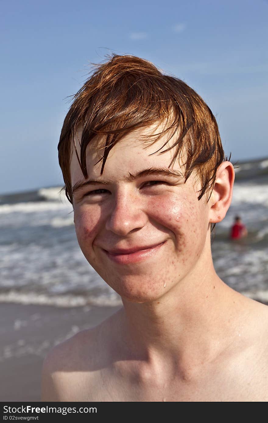 Happy boy with wet hair at the beach