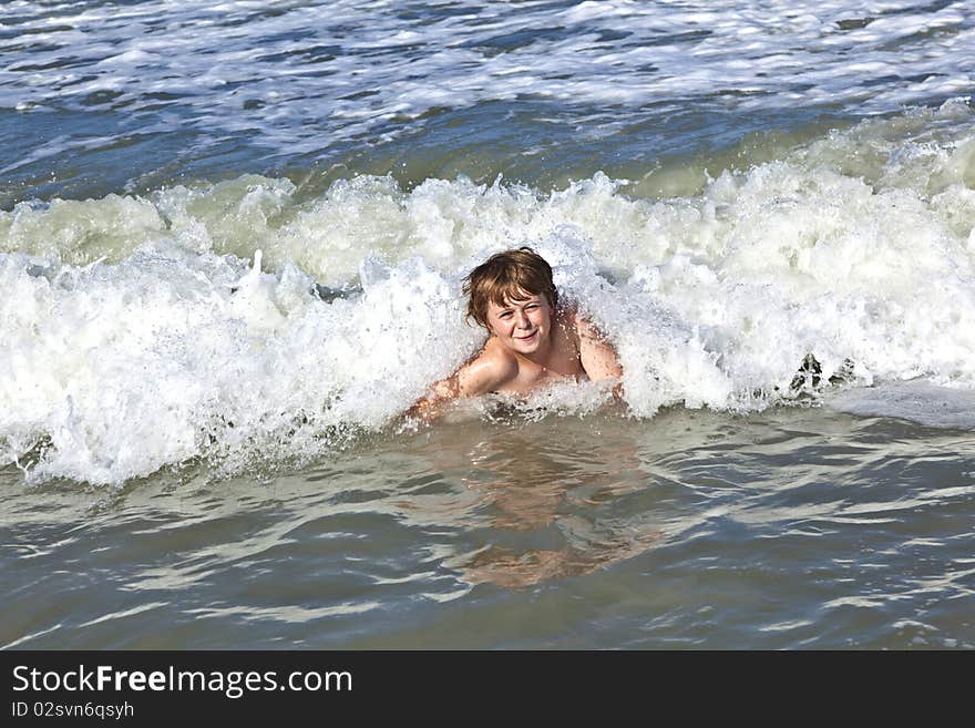 Child has fun in the waves of the ocean