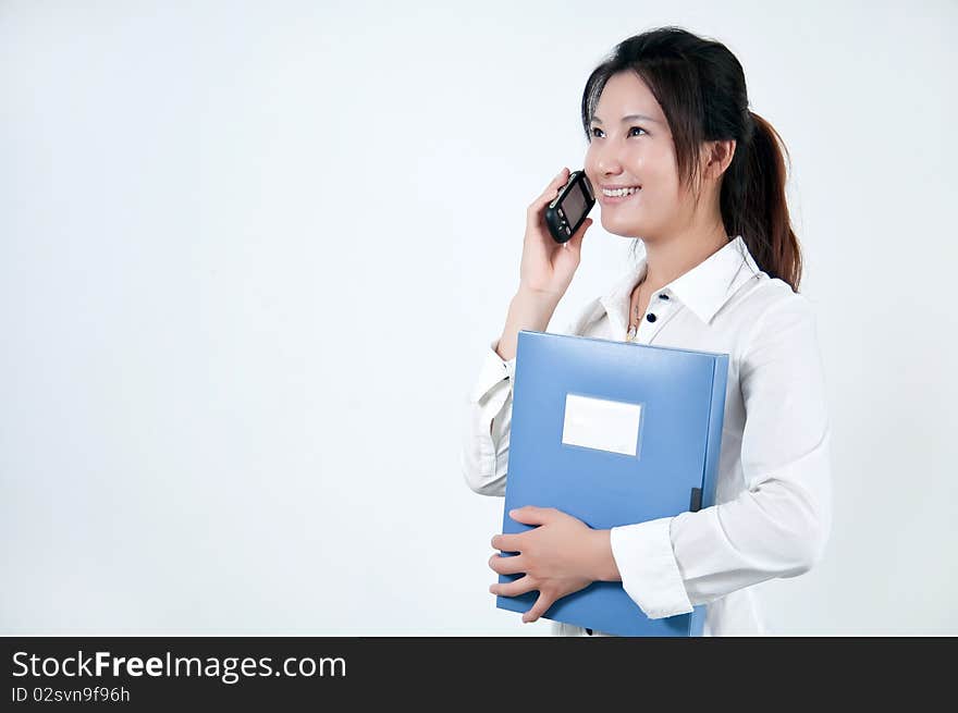 A Beautiful Asian business woman is on the cell phone,who  was carrying a folder