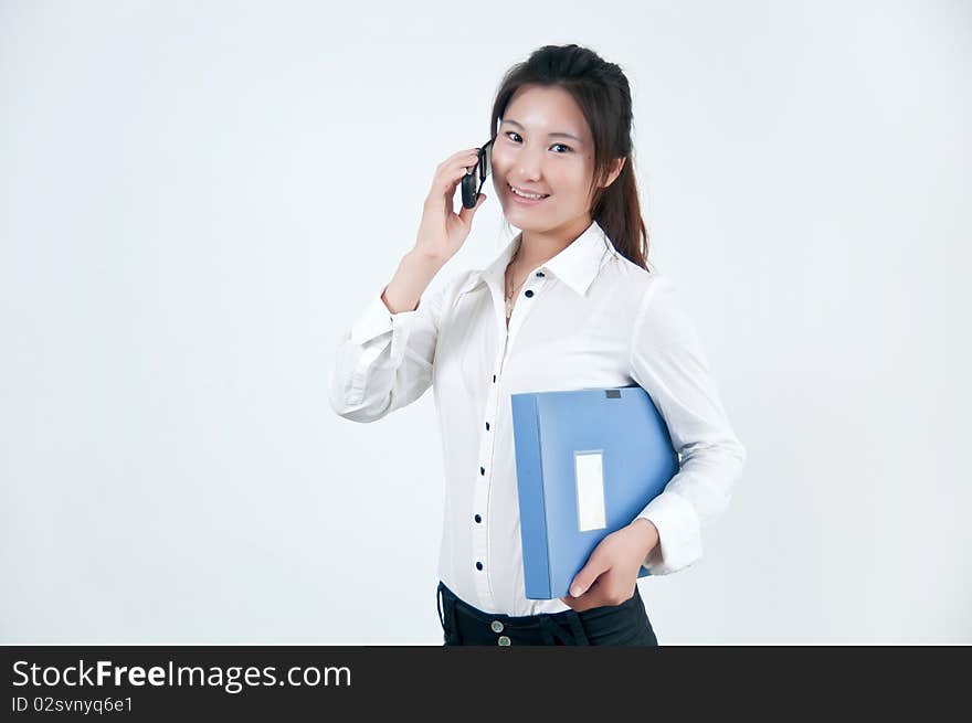 A Beautiful Asian business woman is on the cell phone,who was carrying a folder