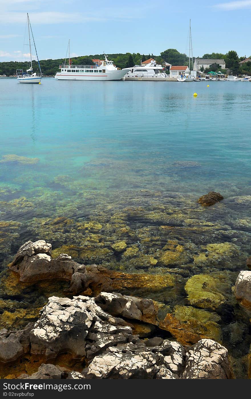 Anchoring yacht and ships in a small bay near Zadar, Croatia, vertical photo. Anchoring yacht and ships in a small bay near Zadar, Croatia, vertical photo