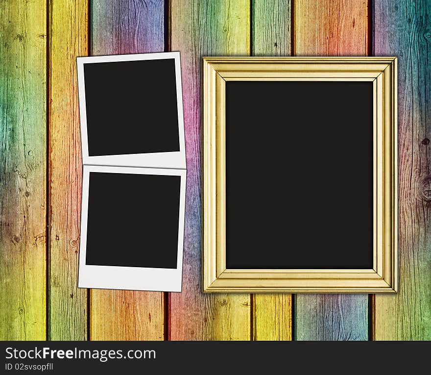 Blank photos and frame on vintage multicolored wooden background