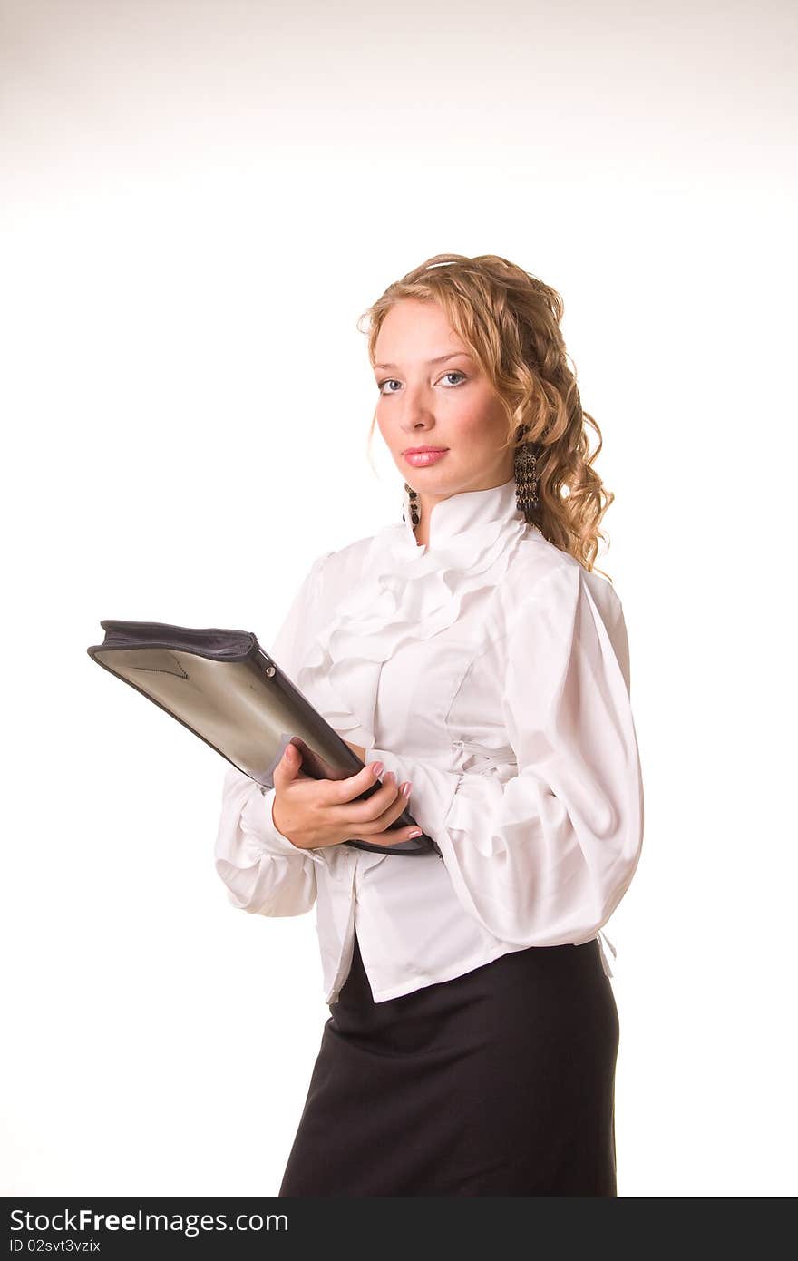 A young business-woman in a white smock and skirt stands with a folder in a hands