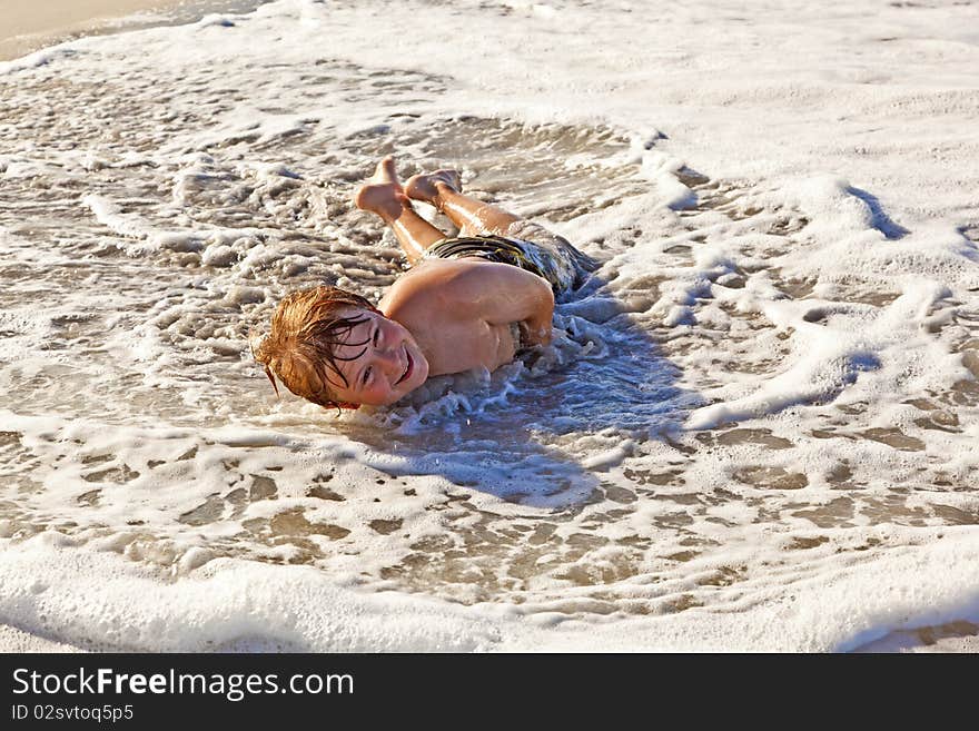 Boy lying at the beach and enjoying the sun