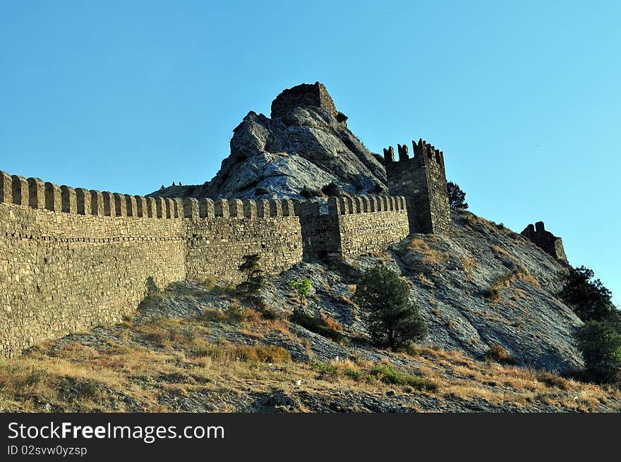 Age-old fortress wall of the Genoese fortress of city pike Perch in Ukraine on a background dark blue sky