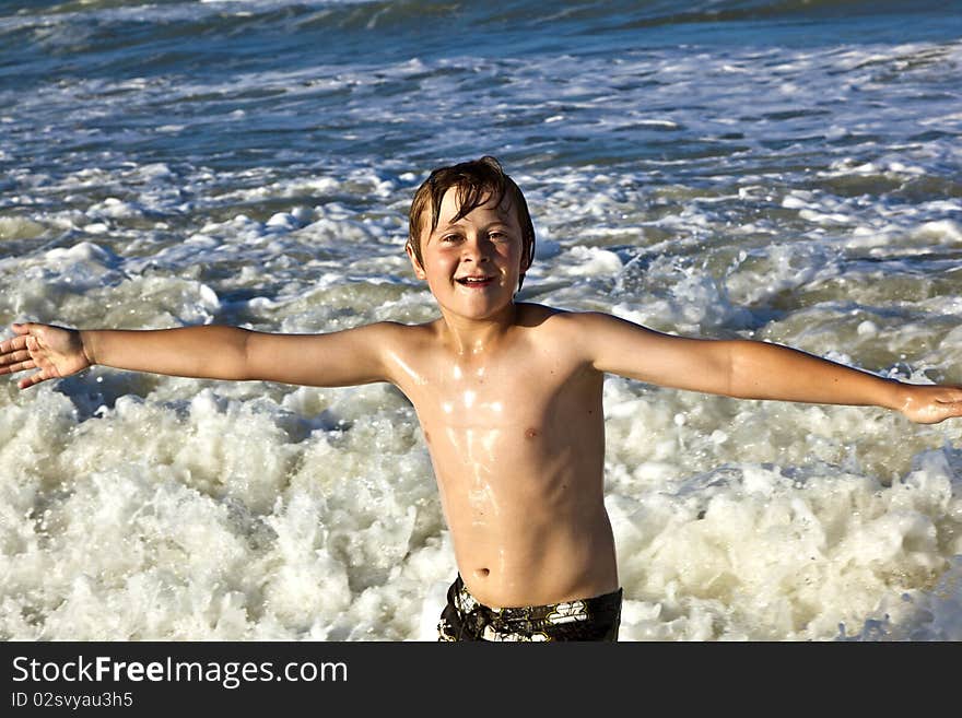 Young boy enjoys the waves of the blue sea