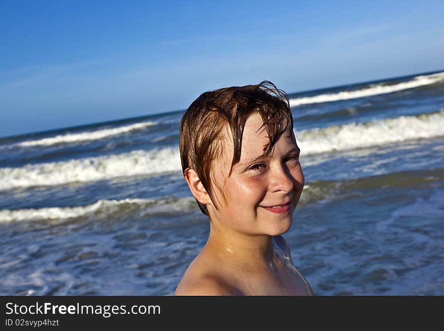 Young boy enjoys the waves of the blue sea