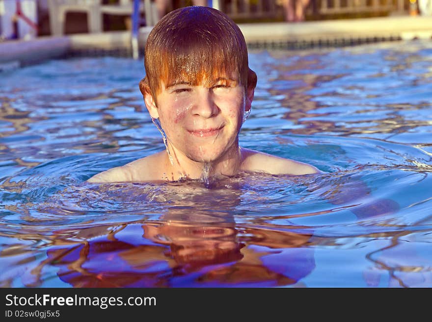 Young child with red hair has fun in the outdoor pool. Young child with red hair has fun in the outdoor pool