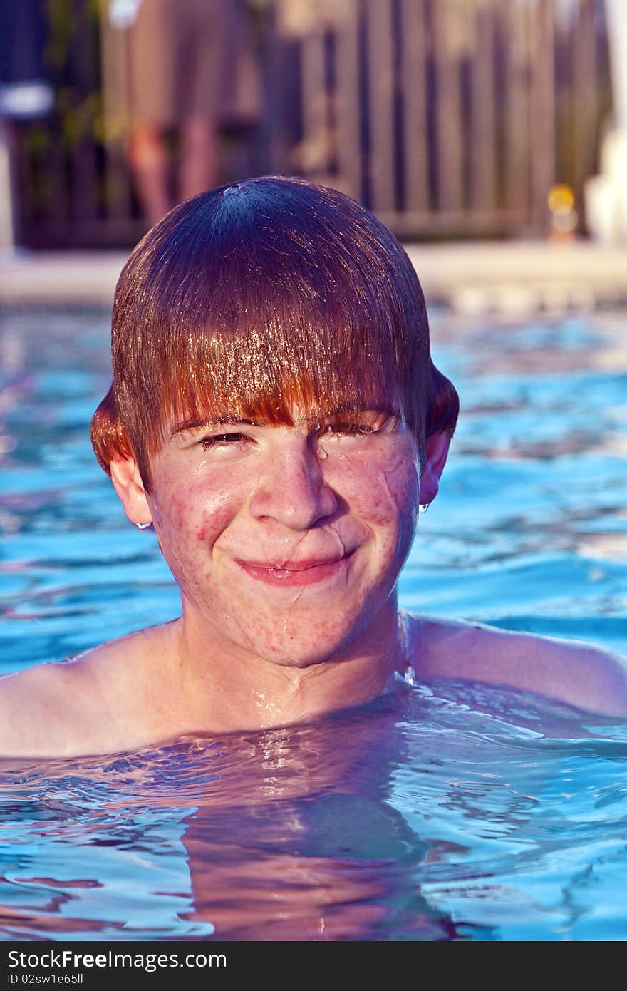 Child with red hair has fun in the outdoor pool. Child with red hair has fun in the outdoor pool